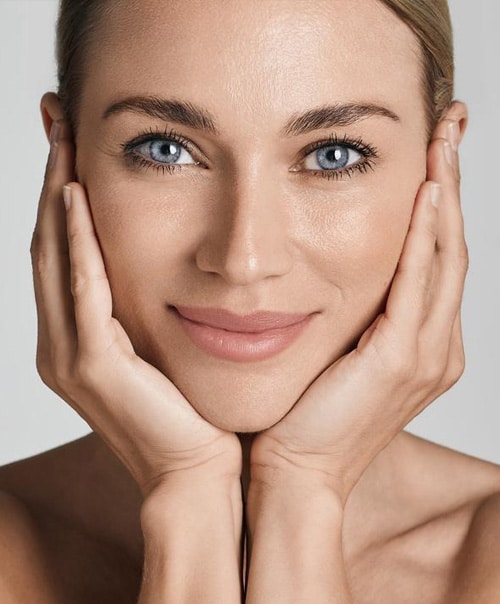 Stock image of Beautiful woman with healthy facial skin touching hands moisturized face skin