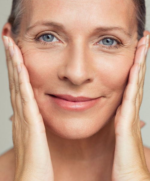 stock image of Closeup face of mature woman with wrinkles massaging face